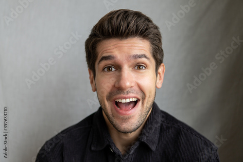 Portrait of a young gorgeous guy with an excited face expression looking it to the camera 