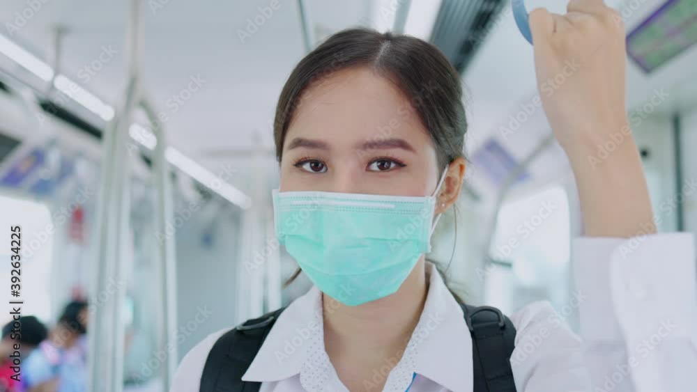 Asian businesswoman wear medical mask to prevent Coronavirus and PM2.5 dust. Travel by train and mass transportation with a social distancing. Urban living in going to work. Concept No Lockdown Asian businesswoman wear medical mask to prevent Coronavirus and PM2.5 dust. Travel by train and mass transportation with a social distancing. Urban living in going to work. Concept No Lockdown