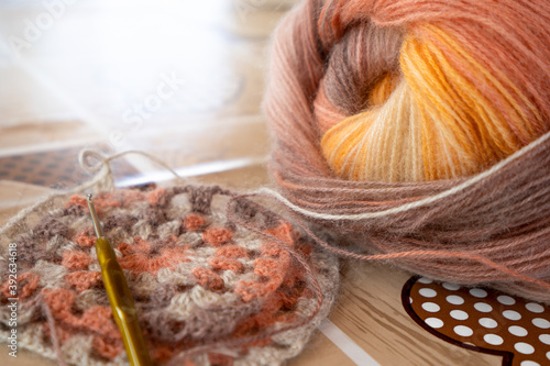 Close-up, grey and multi colored yarns and crochet needle. 