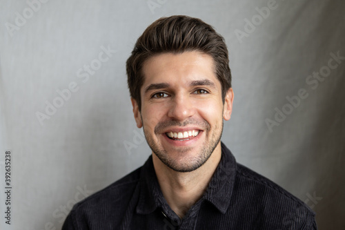 Portrait of a young beautiful man with a wide sparkling smile and perfect teeth