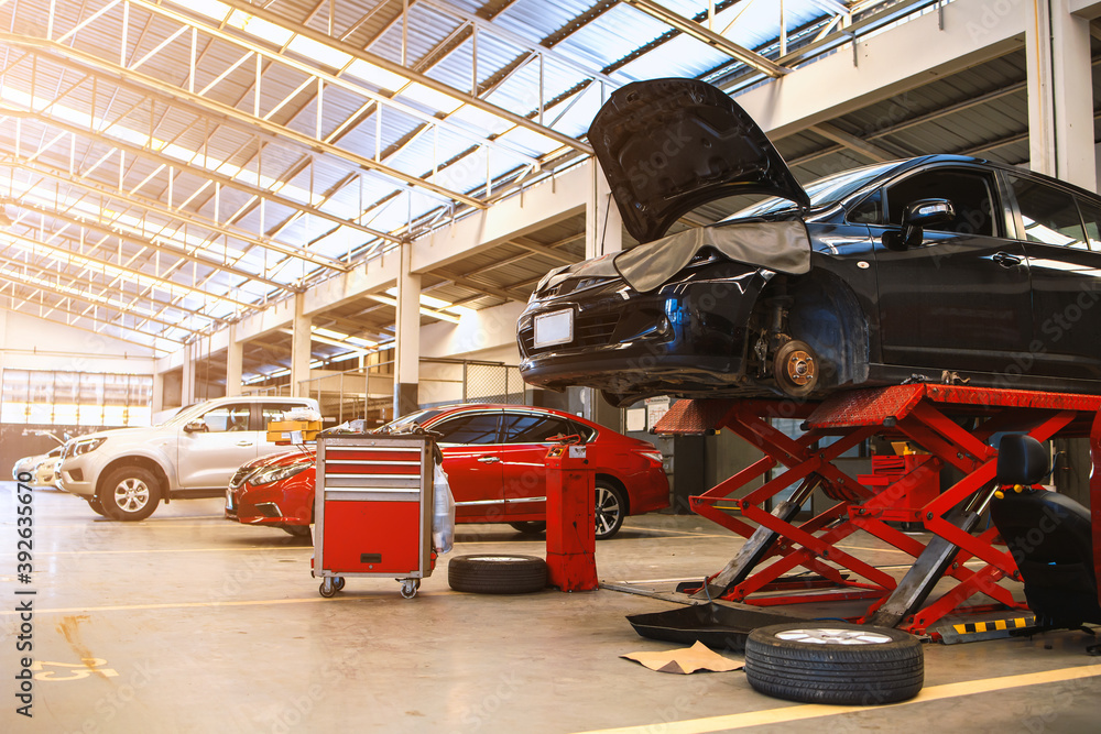 Fototapeta premium car in automobile repair service center with soft-focus and over light in the background