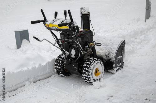 snowblower parked in a park during a snowfall