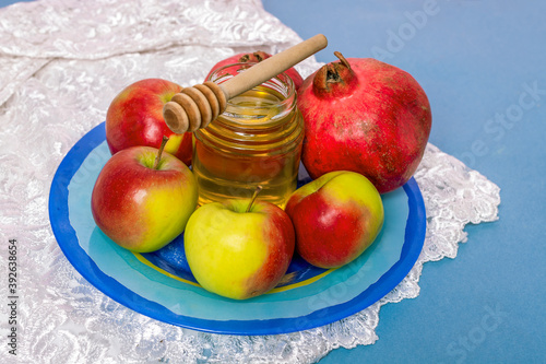 Jar of honey, apples and pomegranates on the table for the holiday of Rosh Hashanah photo