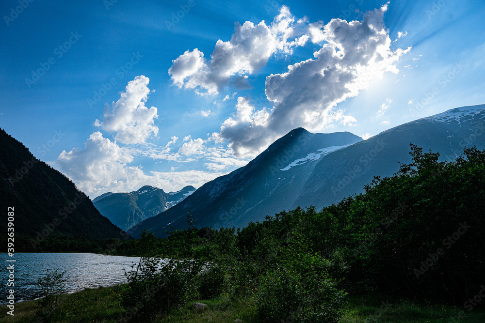 Fototapeta premium Sunbeam through clouds at norwegian mountains