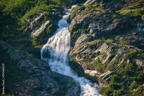 Waterfall on a rock face with green forest