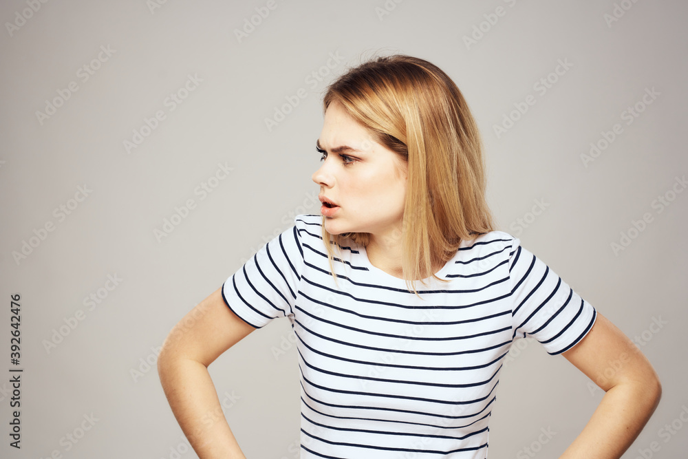 Emotional blonde woman in striped t-shirt lifestyle facial expression close-up Emotional blonde woman in striped t-shirt lifestyle facial expression close-up