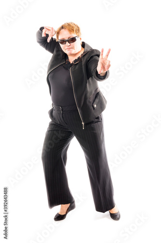 Middle aged woman in black jacket and trousers dancing an emotional dance © idea_studio