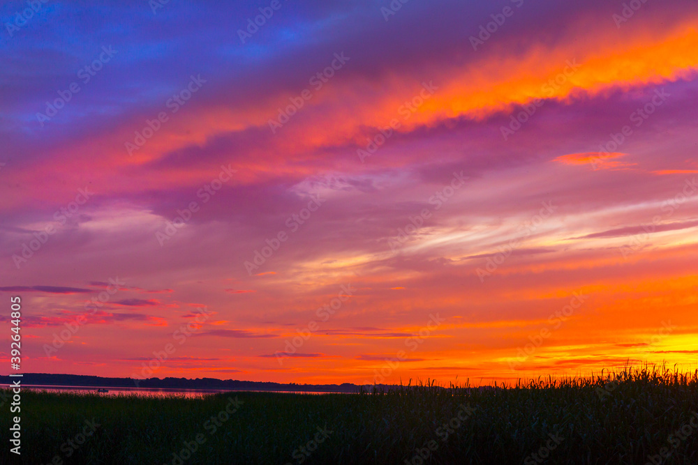 Beautiful colorful sunset over the lake summer landscape.