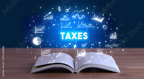 TAXES inscription coming out from an open book, business concept