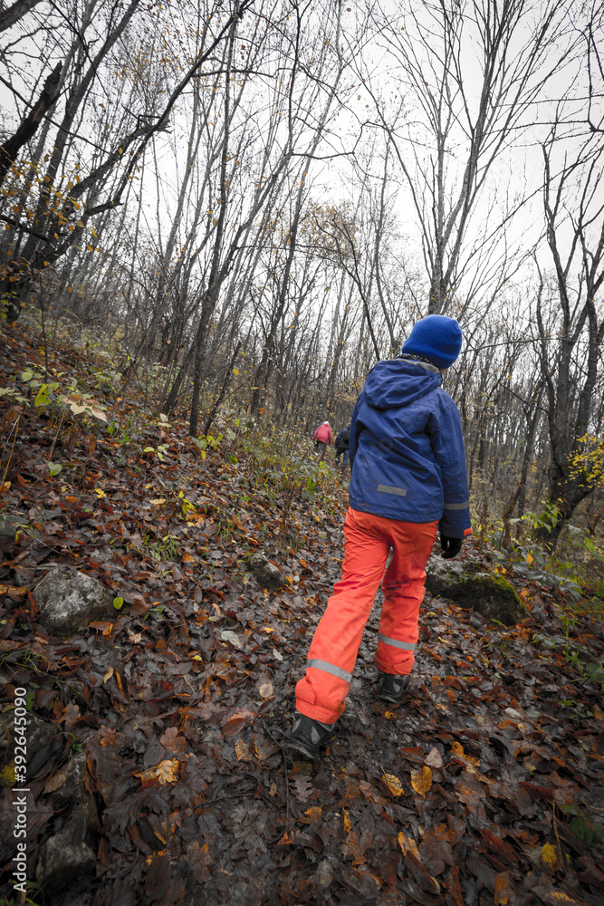 Tired boy hiking in the forest at autumn time. Tired boy hiking in the forest at autumn time.