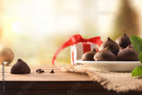 Chocolate truffles on plate on wooden table In Christmas front