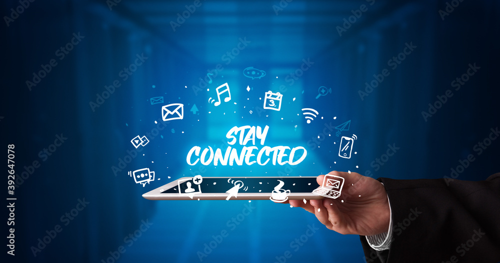 Young business person working on tablet and shows the inscription: STAY CONNECTED Young business person working on tablet and shows the inscription: STAY CONNECTED