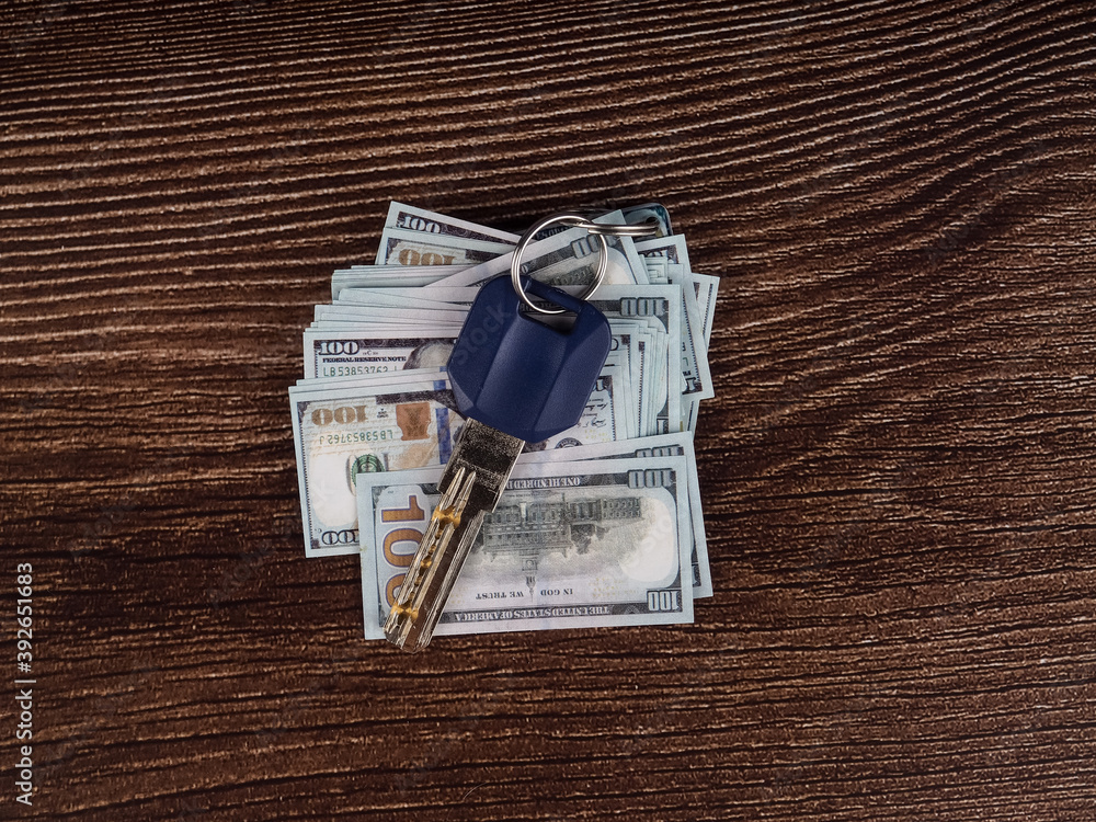 keys next to artificial dollar bills, buy your own home or car, open doors for money