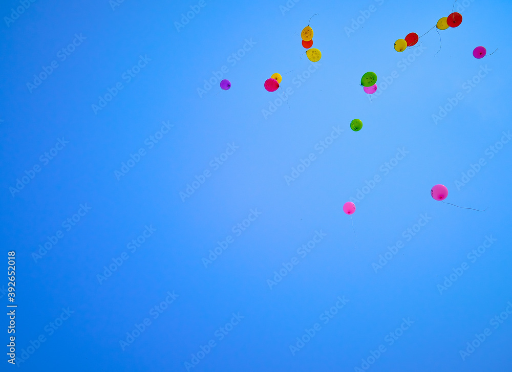 Multicolored balloons flying high in the blue sky Multicolored balloons flying high in the blue sky
