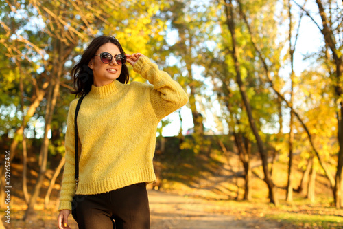 Beautiful young woman wearing stylish sweater in autumn park