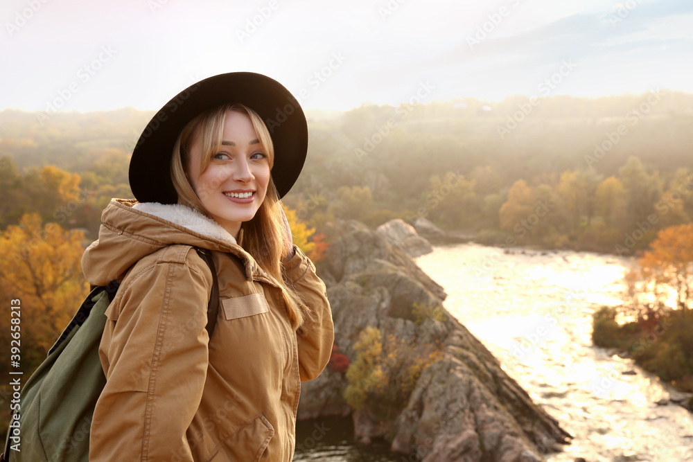 Woman with backpack enjoying beautiful view near mountain river Woman with backpack enjoying beautiful view near mountain river