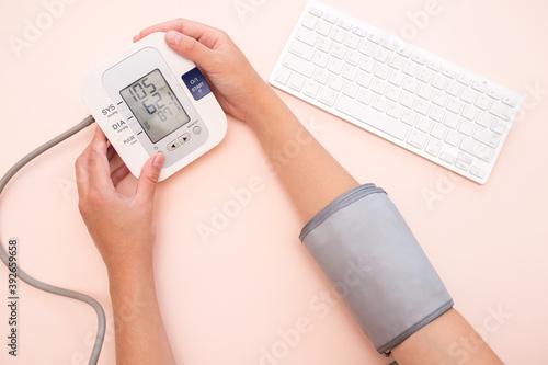 Measurement of pressure. A woman monitors her health by checking the pressure and pulse on her arm. View from above