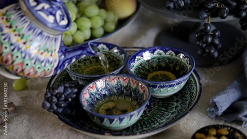 Woman pouring tea in the cup in Uzbekistan photo