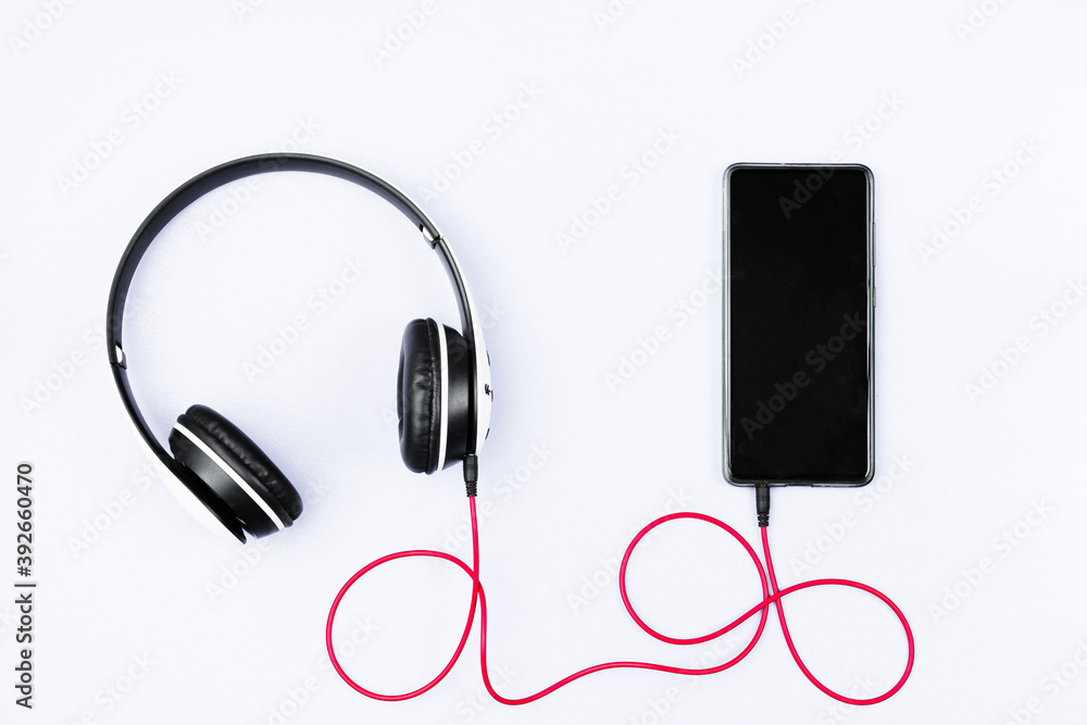 Headset and a phone on a white background. Ready to listen to music. Headset and a phone on a white background. Ready to listen to music.