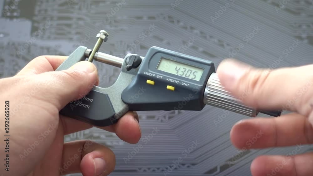 Engineer working with precise micrometer with digital display for
