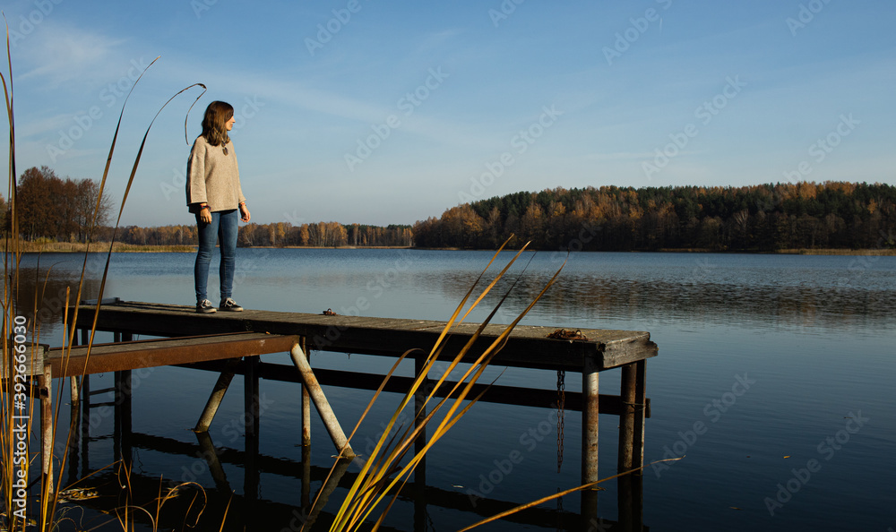 Attractive young female standing on top of a pier while witnessing the Galve lake in Trakai, Lithuania. Trakai was the ancient capital of this baltic republic. Attractive young female standing on top of a pier while witnessing the Galve lake in Trakai, Lithuania. Trakai was the ancient capital of this baltic republic.