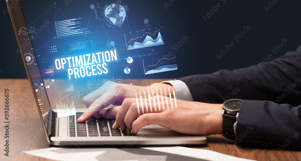 Businessman working on laptop with OPTIMIZATION PROCESS inscription, new business concept Businessman working on laptop with OPTIMIZATION PROCESS inscription, new business concept