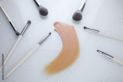 a smear of makeup Foundation and brush on a white background