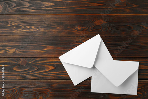 White paper envelopes on wooden background, flat lay. Space for text photo