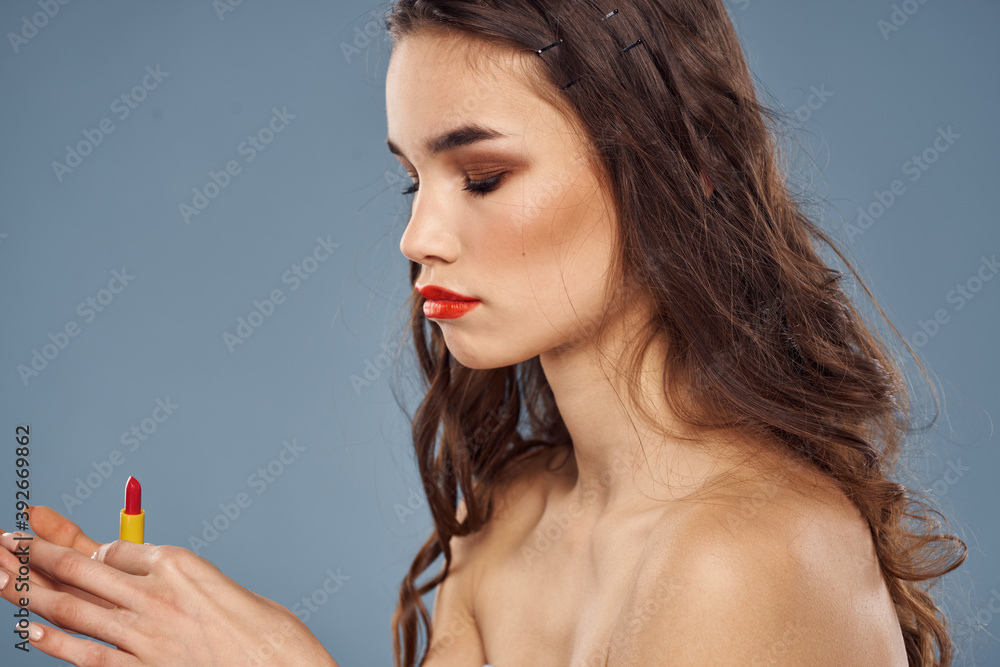 Obraz premium Woman with lipstick on a gray background brunette makeup with eye shadow on the eyelids
