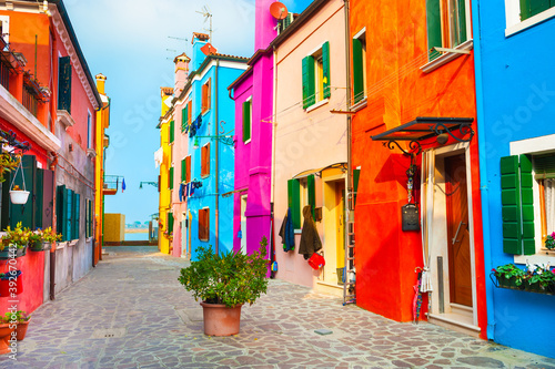 Colorful architecture in Burano island, Venice, Italy. Cozy courtyard with flowers. Famous travel destination