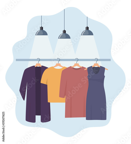 Clothes hang on a hanger, illuminated by lamps. Fashion boutique, assortment showroom. Women's personal wardrobe, dressing room. Trousers, summer dress on hangers. Vector illustration.