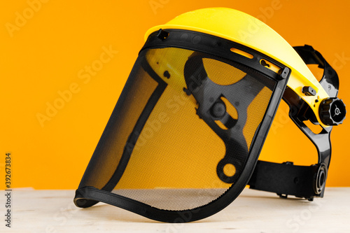 Yellow construction mask-grid on a wooden table on a yellow background. photo