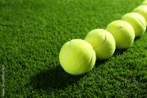 Tennis balls on green grass. Sports equipment © New Africa