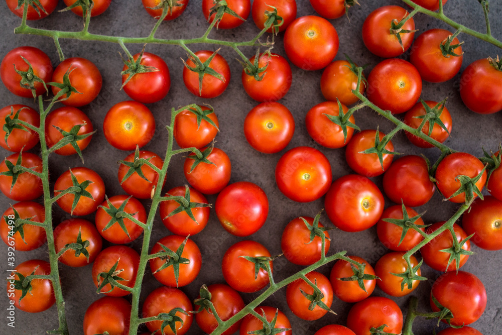 A lot of cherry tomatoes on a table. Grey background. Top view photo of fresh vegetables. 