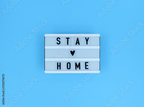 Light box with Stay home quote on a blue background.