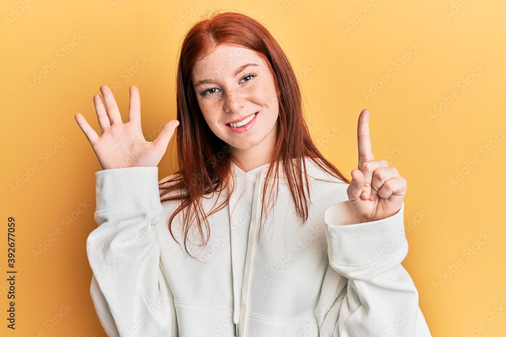 Young red head girl wearing casual sweatshirt showing and pointing up with fingers number six while smiling confident and happy. Young red head girl wearing casual sweatshirt showing and pointing up with fingers number six while smiling confident and happy.