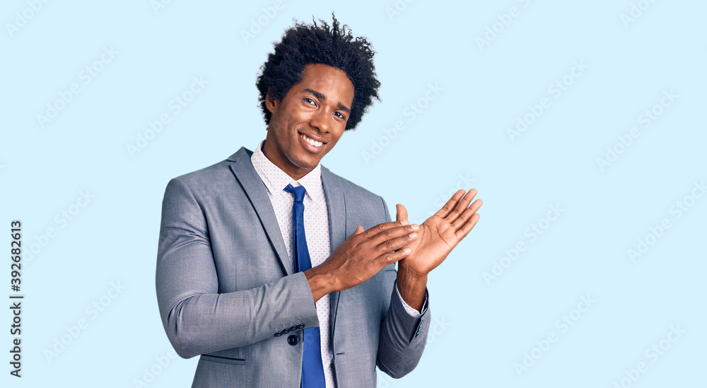 Handsome african american man with afro hair wearing business jacket clapping and applauding happy and joyful, smiling proud hands together Handsome african american man with afro hair wearing business jacket clapping and applauding happy and joyful, smiling proud hands together