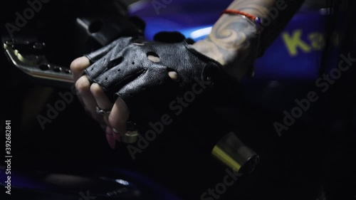 Woman squeezes clutch lever on sport bike. Motorcyclist's hand in a black glove