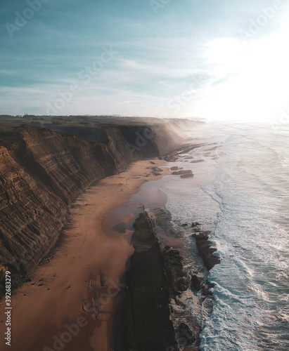 Aerial view of waves on a beautiful sandy ocean beach and cliff. Panorama atlantic coastline.