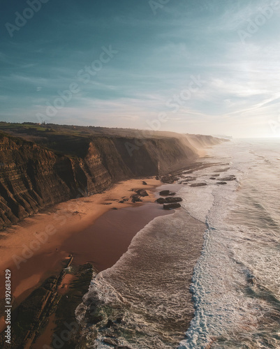 Aerial view of waves on a beautiful sandy ocean beach and cliff. Panorama atlantic coastline.