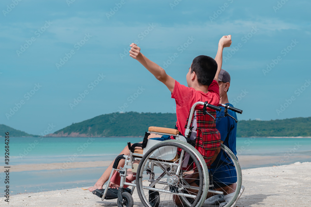 Asian special child on wheelchair is smiling, playing, doing activity on sea beach with father,Lifestyle of disability child, Life in the education age, Happy disabled kid in travel holidays concept. Asian special child on wheelchair is smiling, playing, doing activity on sea beach with father,Lifestyle of disability child, Life in the education age, Happy disabled kid in travel holidays concept.