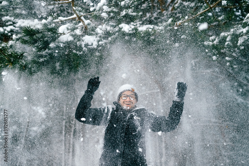 Happy smiling man under tha falling snow