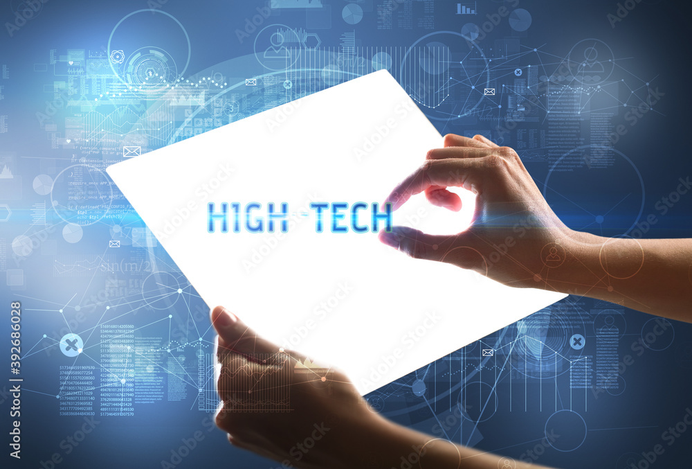 Hand holdig futuristic tablet with HIGH-TECH inscription, new technology concept Hand holdig futuristic tablet with HIGH-TECH inscription, new technology concept