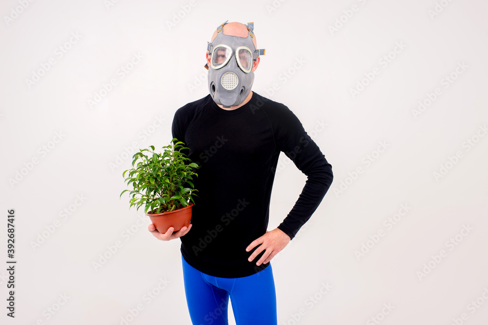 Funny strange man in respirator posing with a flower in the pot over white background Funny strange man in respirator posing with a flower in the pot over white background