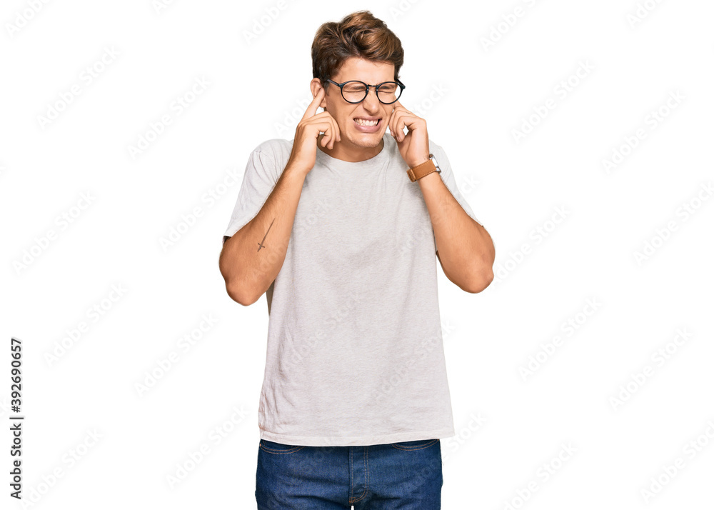 Handsome caucasian man wearing casual clothes and glasses covering ears with fingers with annoyed expression for the noise of loud music. deaf concept. Handsome caucasian man wearing casual clothes and glasses covering ears with fingers with annoyed expression for the noise of loud music. deaf concept.