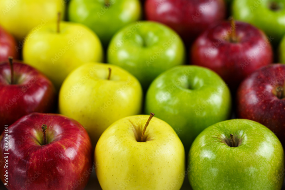 Grupo de manzanas de diferentes colores y variedades dispuestas en fila con desenfoque del fondo. Grupo de manzanas de diferentes colores y variedades dispuestas en fila con desenfoque del fondo.