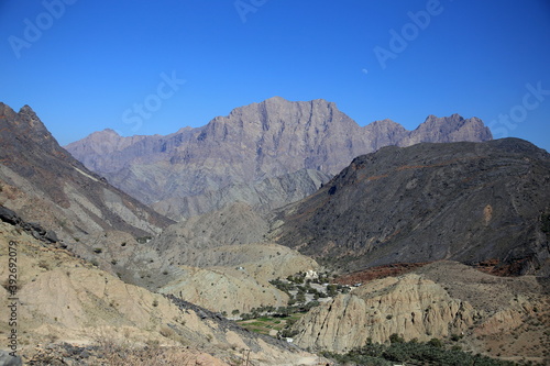 View of the green valley among the arid mountains of different rocks and colors, Wadi Bani Awf, Al Rustaq, South Batinah Governorate of Oman
