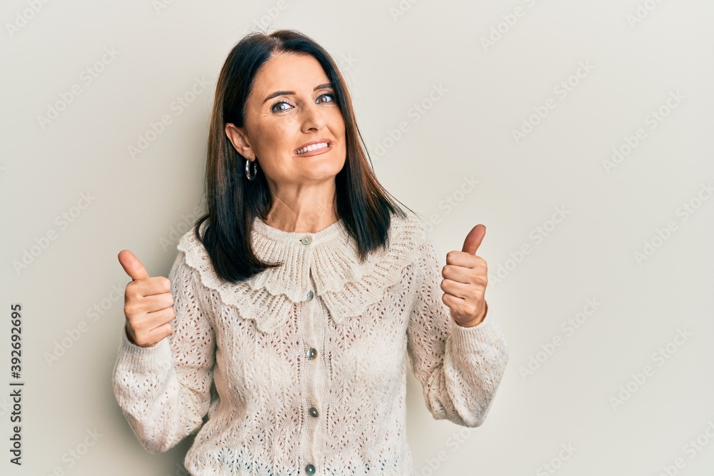 Middle age brunette woman wearing casual clothes success sign doing positive gesture with hand, thumbs up smiling and happy. cheerful expression and winner gesture. Middle age brunette woman wearing casual clothes success sign doing positive gesture with hand, thumbs up smiling and happy. cheerful expression and winner gesture.