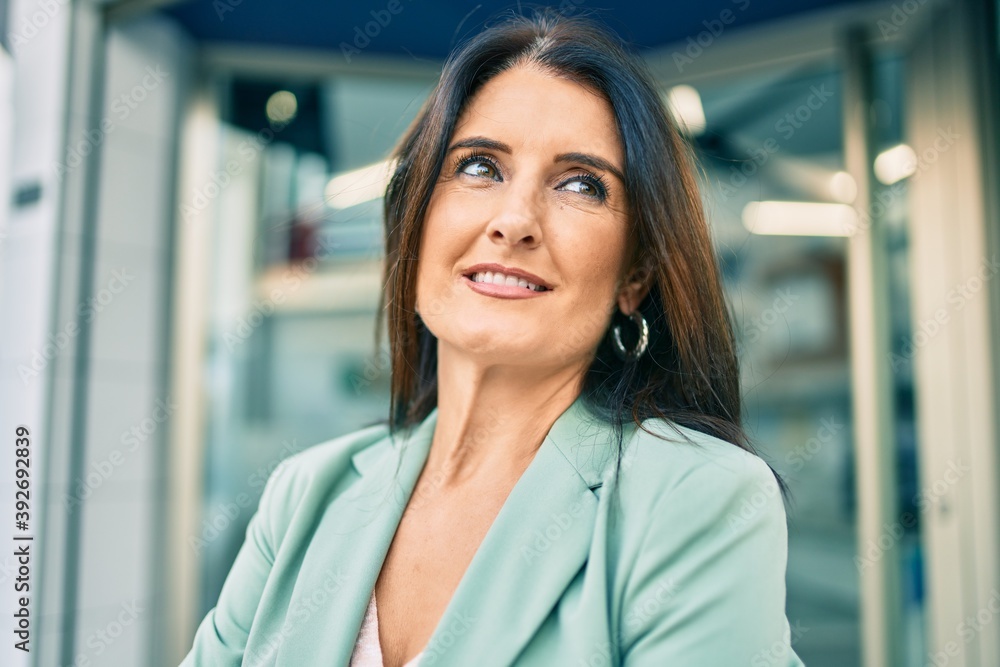 Fototapeta premium Confident business woman wearing elegant suit standing at the street with cheerful face