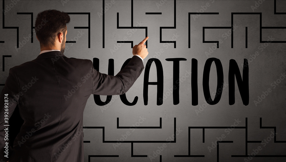 businessman drawing maze with EDUCATION inscription, business education concept businessman drawing maze with EDUCATION inscription, business education concept